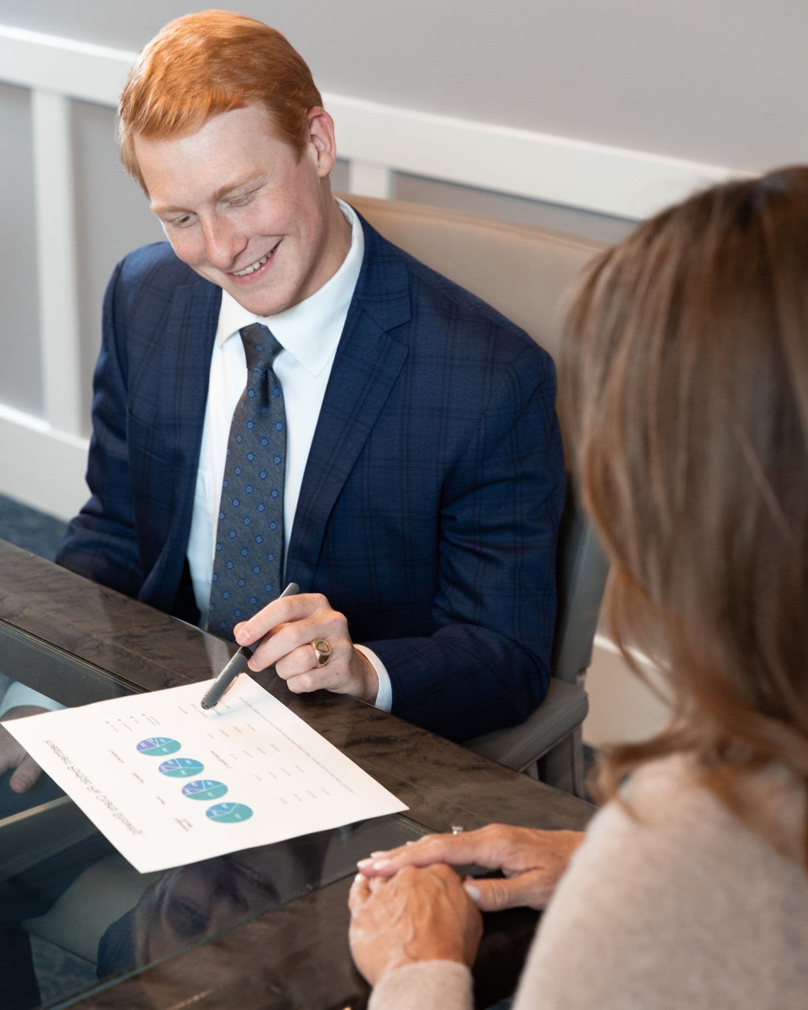 An OmniStar advisor pointing out a detail on a chart while a client considers it